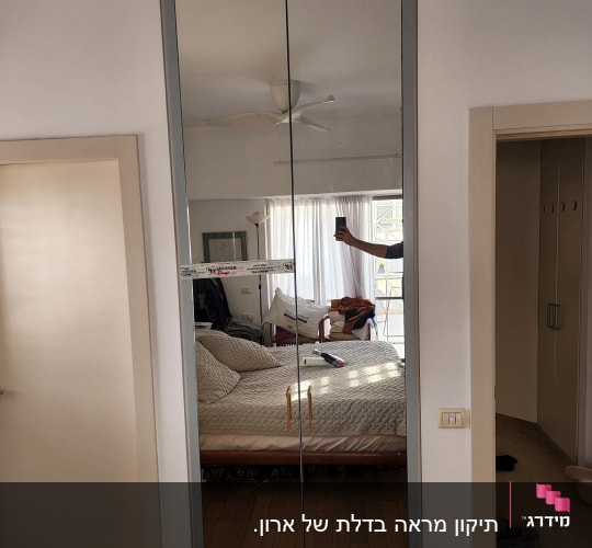 מראה גדולה עם מסגרת אפורה בחדר שינה